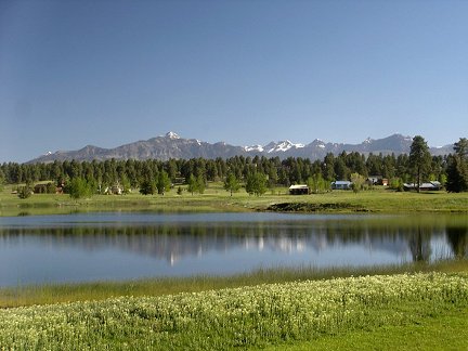Snow capped peaks of the Rocky Mountains reflected in a lake in Pagosa Springs, Colorado. 